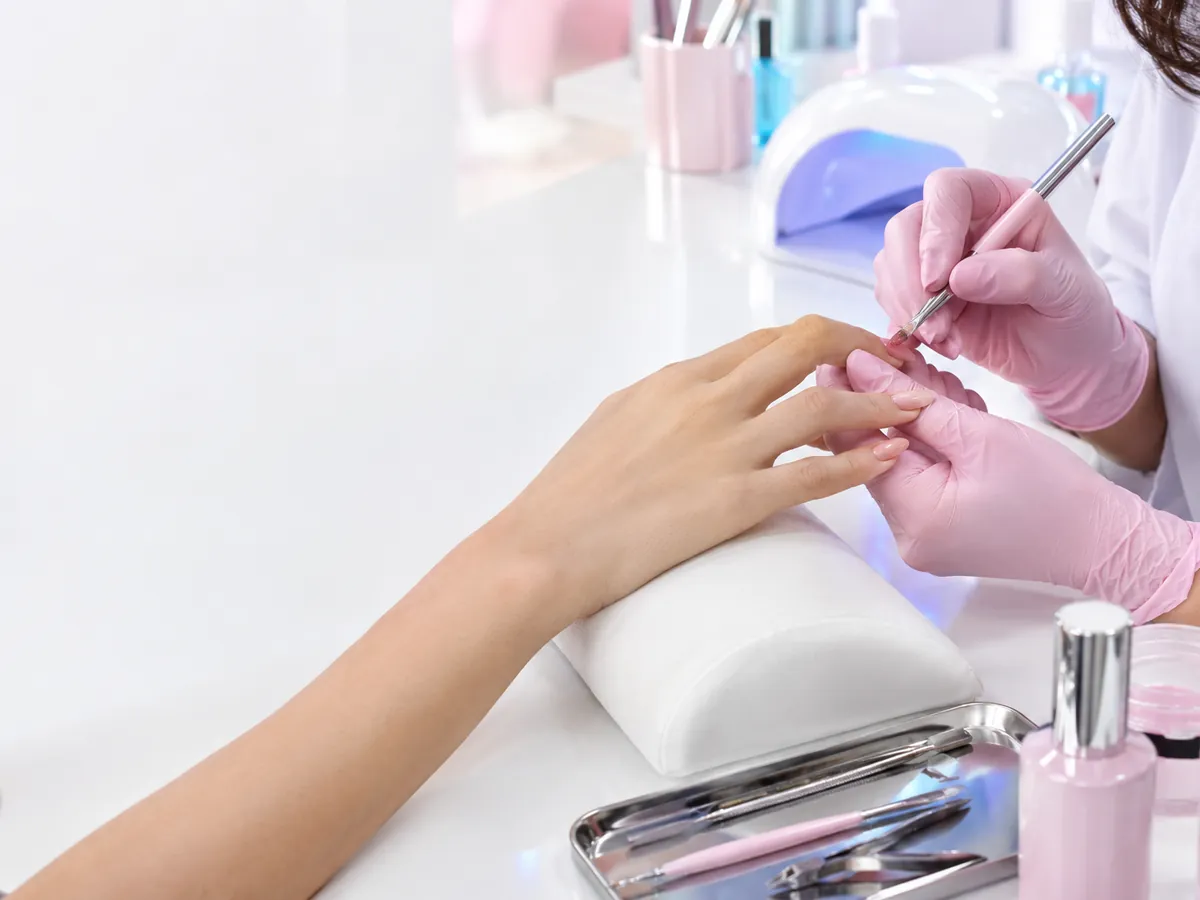 متخصص ناخن در حال کاشت ناخن برای مشتری